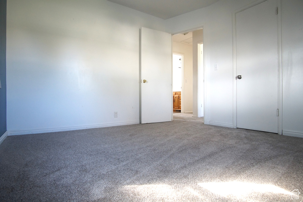 Unfurnished bedroom with baseboards and light carpet