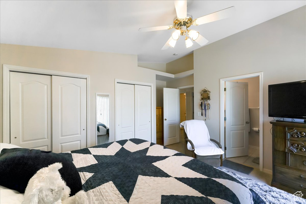 Bedroom with baseboards, lofted ceiling, two closets, and ceiling fan