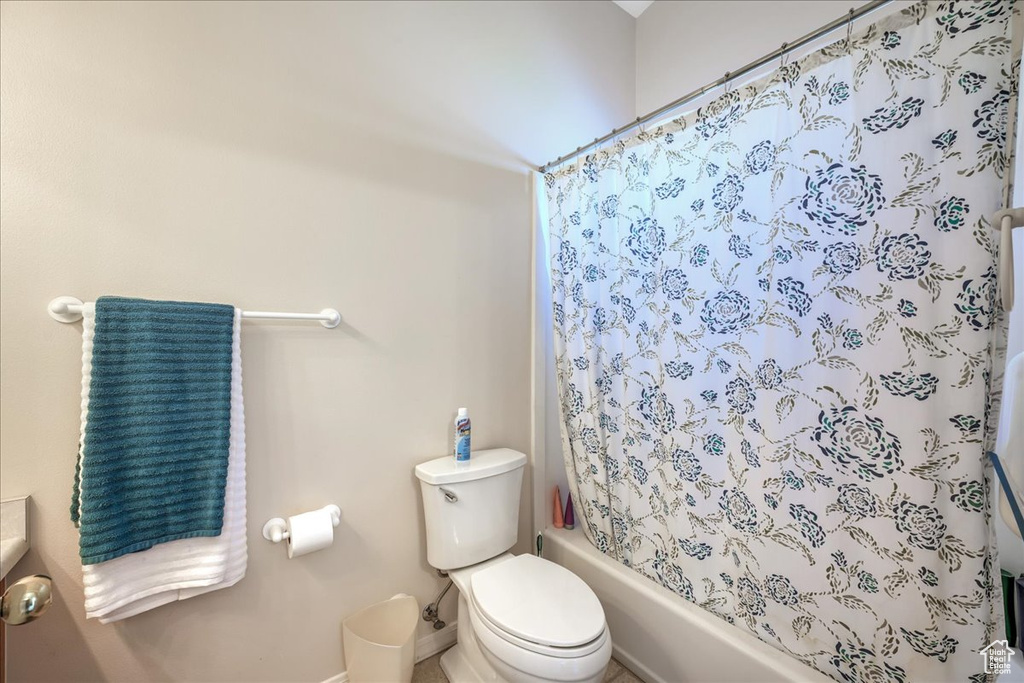 Bathroom featuring shower / tub combo and toilet