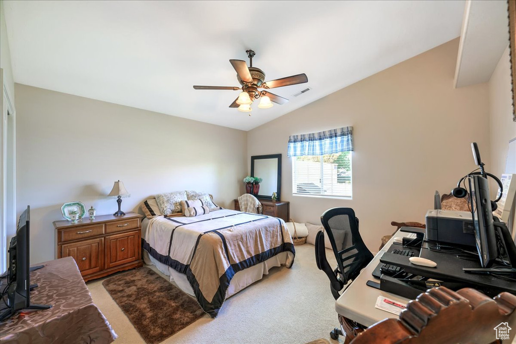 Bedroom featuring light colored carpet, vaulted ceiling, visible vents, and a ceiling fan