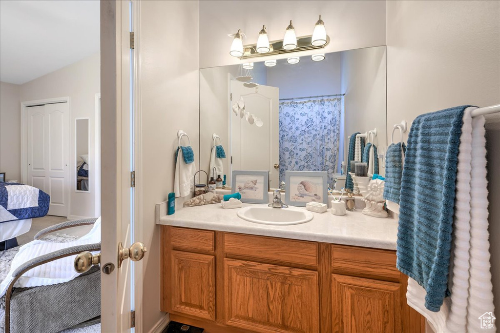 Full bath with ensuite bath, lofted ceiling, and vanity