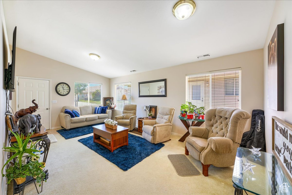 Living area featuring baseboards, carpet floors, visible vents, and vaulted ceiling