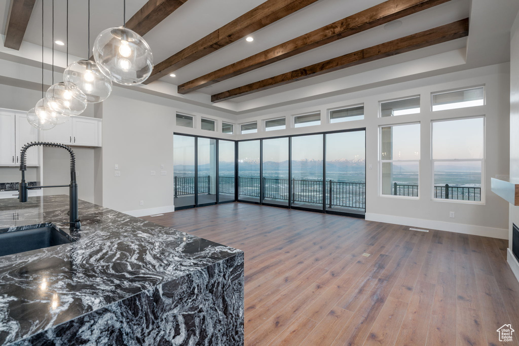 Living room featuring wood finished floors, beam ceiling, baseboards, and recessed lighting