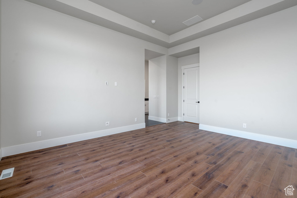 Empty room featuring dark wood-style floors and baseboards