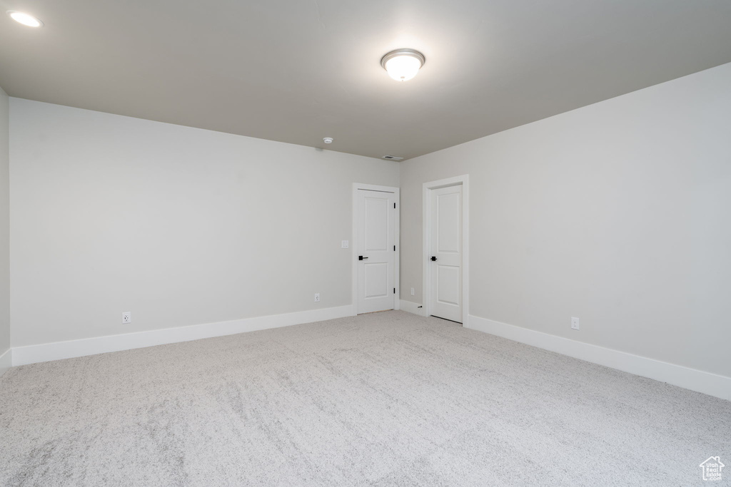 Carpeted empty room with baseboards and recessed lighting