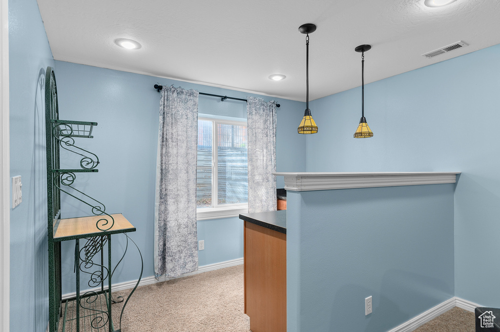 Interior space with baseboards, carpet flooring, visible vents, and dark countertops