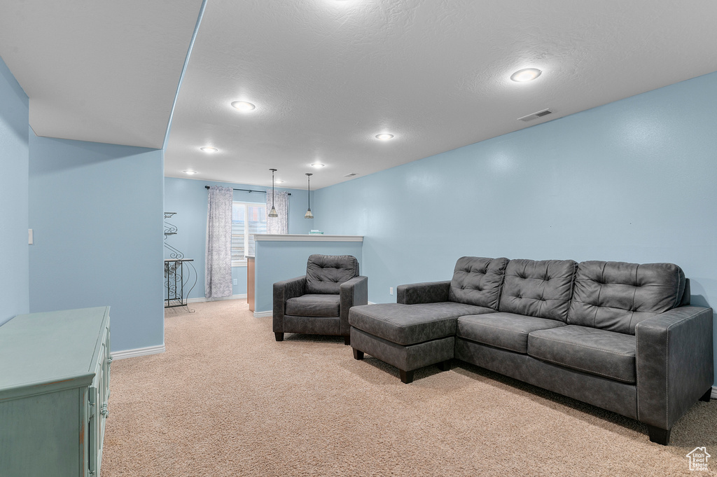Living area featuring recessed lighting, baseboards, light colored carpet, and visible vents