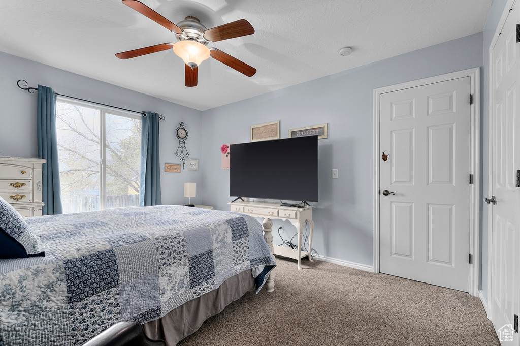 Bedroom with baseboards, a ceiling fan, and carpet