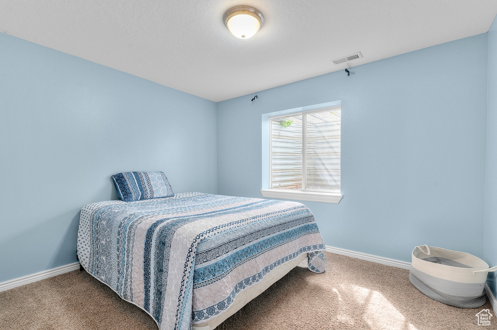 Carpeted bedroom with baseboards and visible vents
