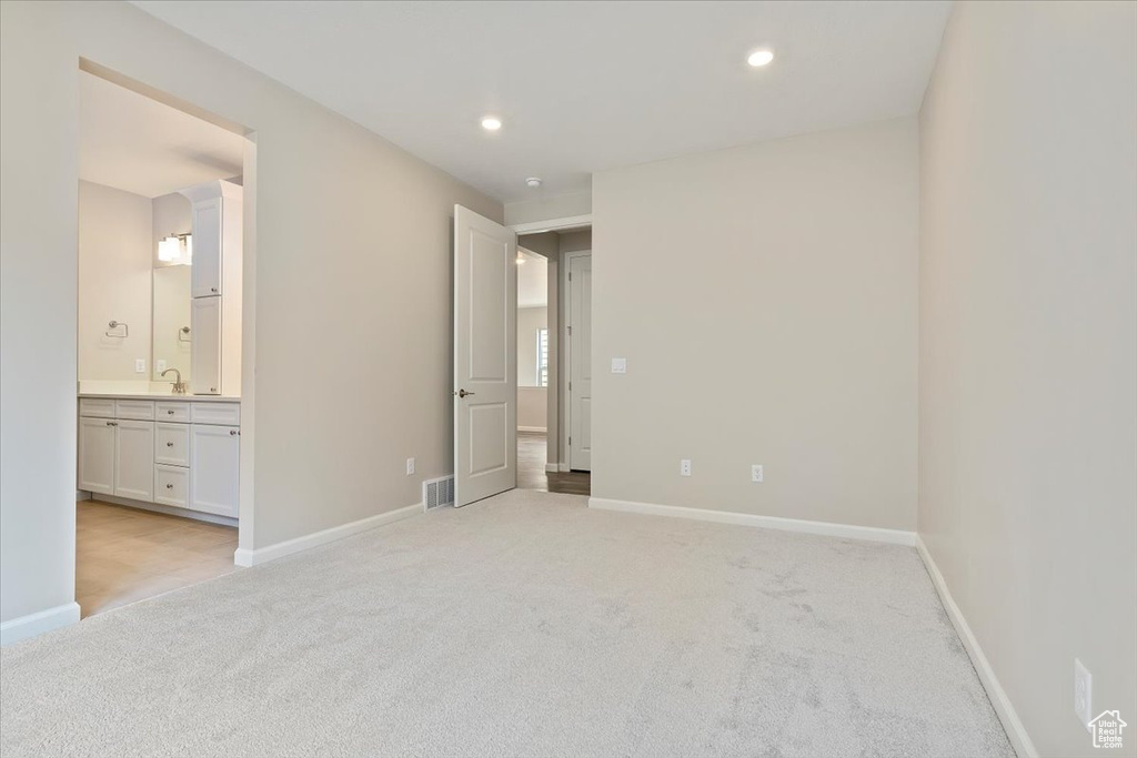 Unfurnished bedroom featuring light carpet, baseboards, visible vents, and recessed lighting