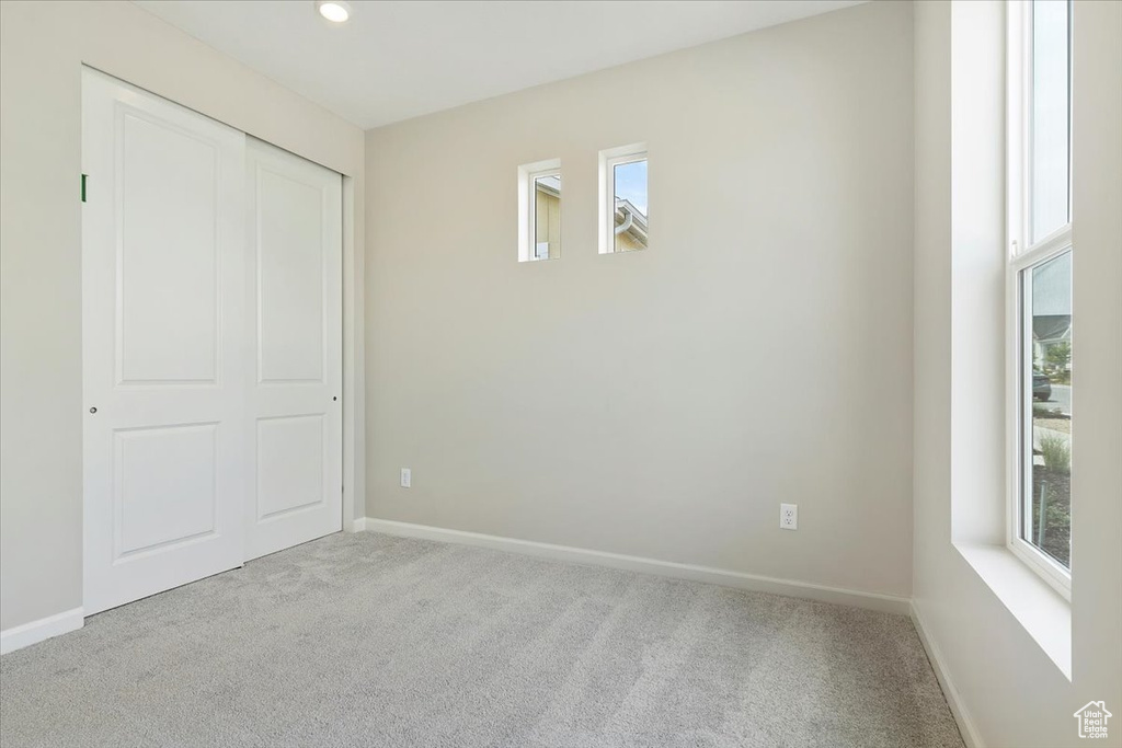 Unfurnished bedroom featuring baseboards, carpet floors, and a closet