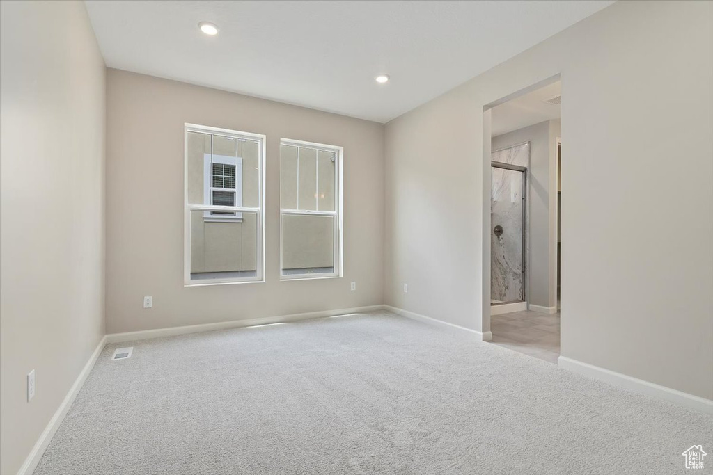 Empty room featuring baseboards, visible vents, recessed lighting, and carpet