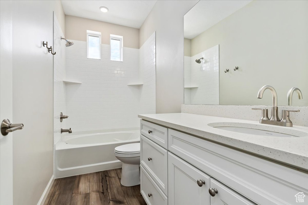 Full bathroom featuring shower / washtub combination, wood finished floors, toilet, and vanity