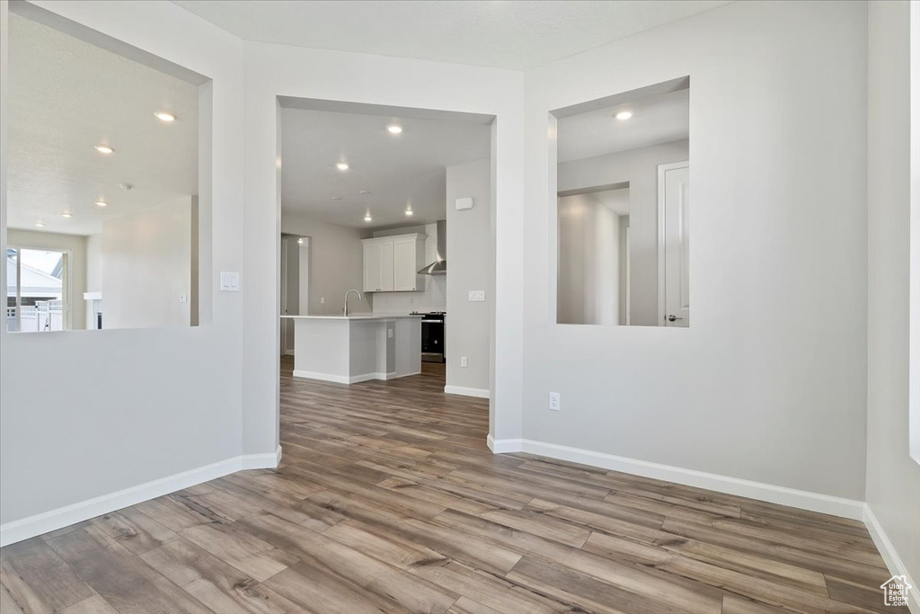 Interior space featuring a sink, baseboards, wood finished floors, and recessed lighting