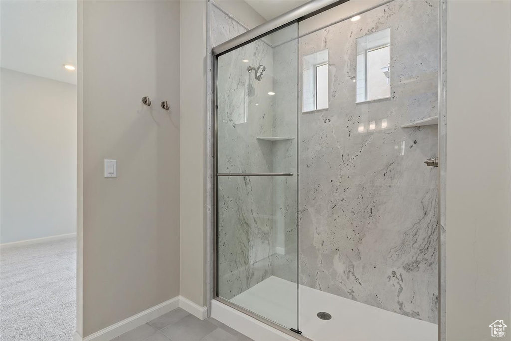 Bathroom with baseboards and a marble finish shower
