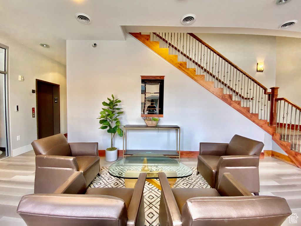 Living area with elevator, visible vents, and wood finished floors