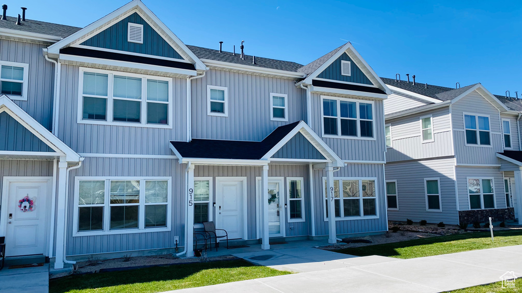 View of property with board and batten siding and a front yard