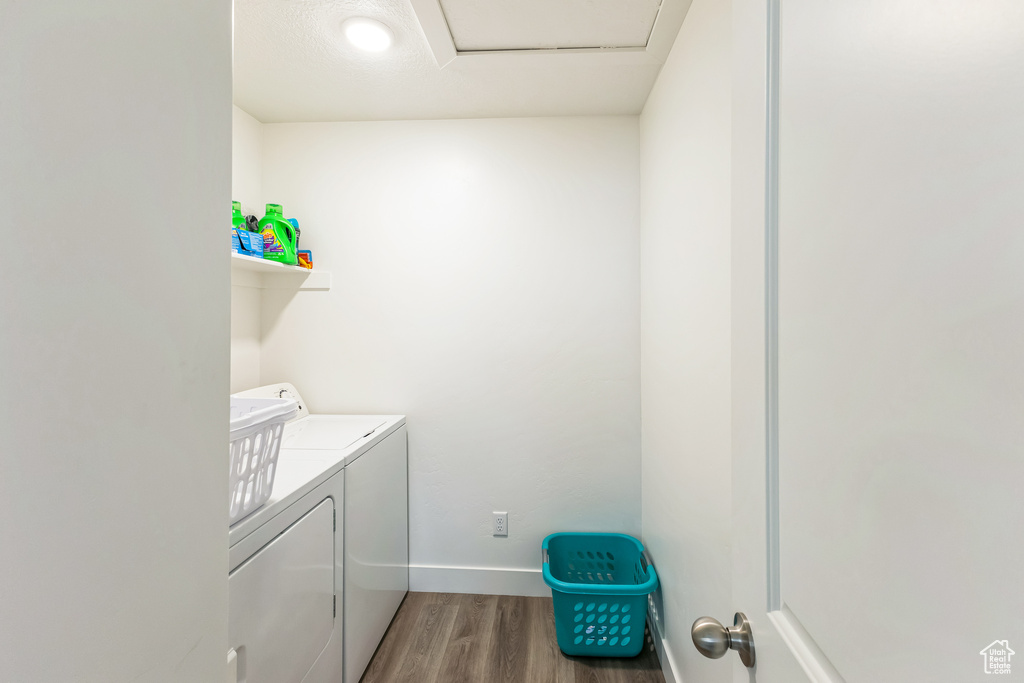 Laundry area with attic access, baseboards, washer and dryer, laundry area, and wood finished floors