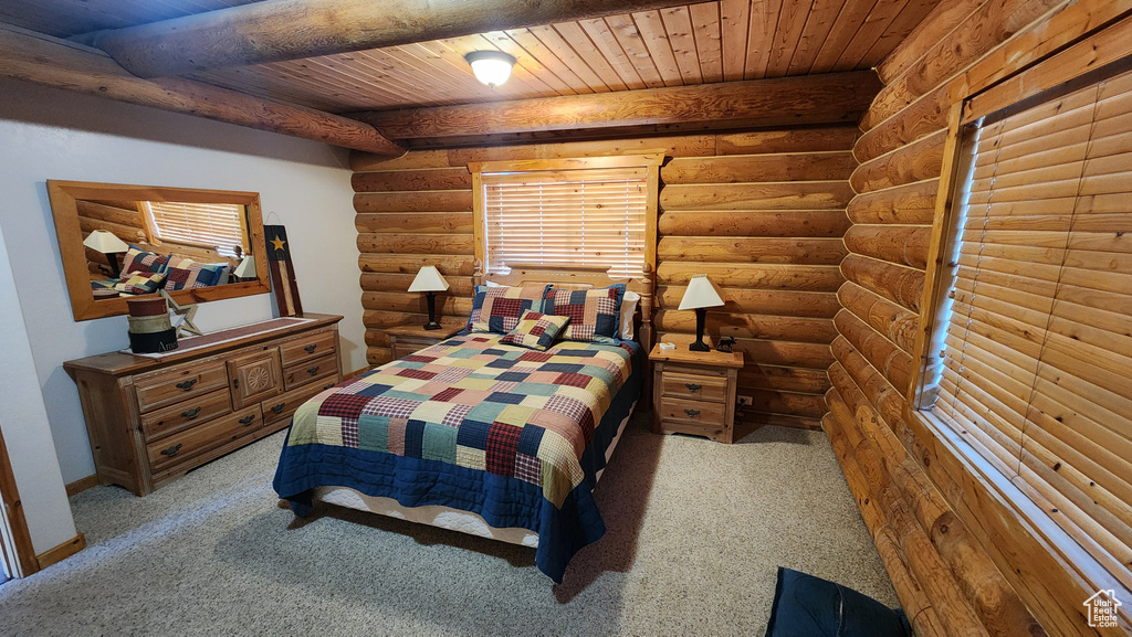 Carpeted bedroom with rustic walls, wooden ceiling, and beam ceiling