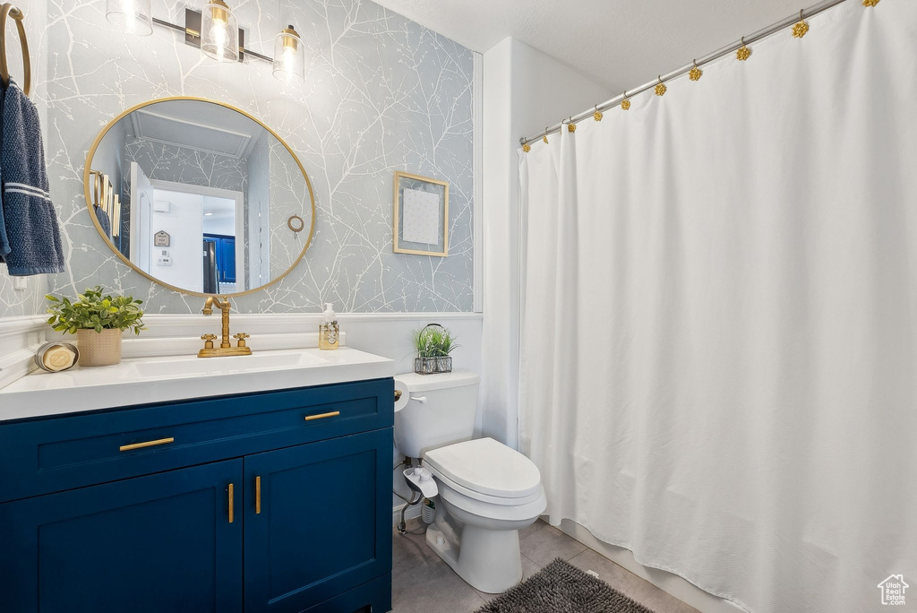 Full bathroom featuring tile patterned flooring, vanity, toilet, a shower with shower curtain, and wallpapered walls