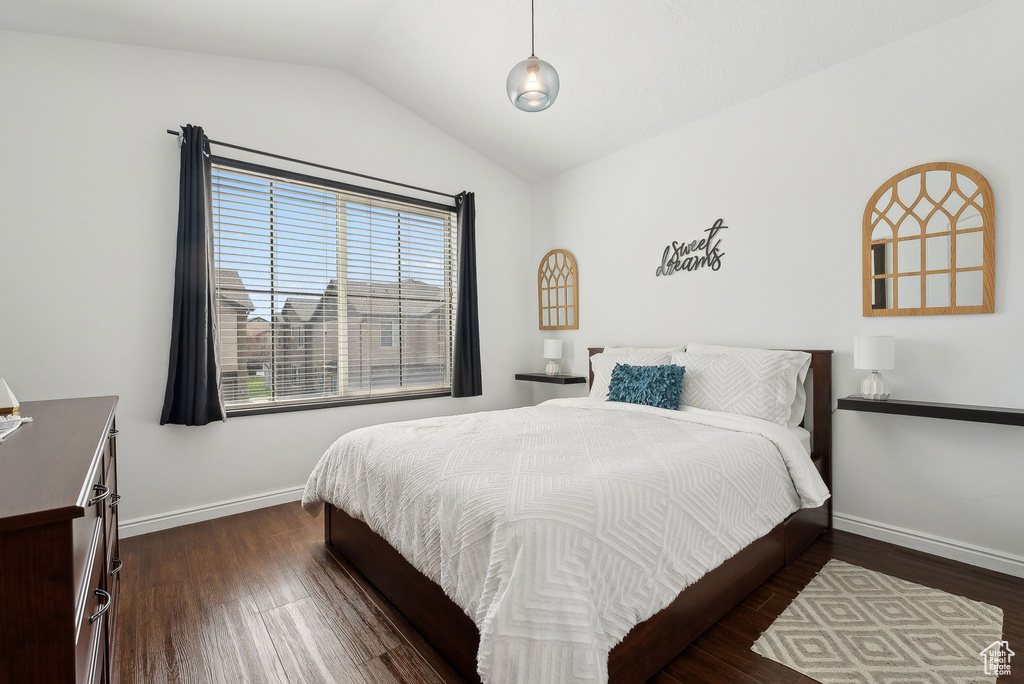 Bedroom with baseboards, vaulted ceiling, and dark wood finished floors