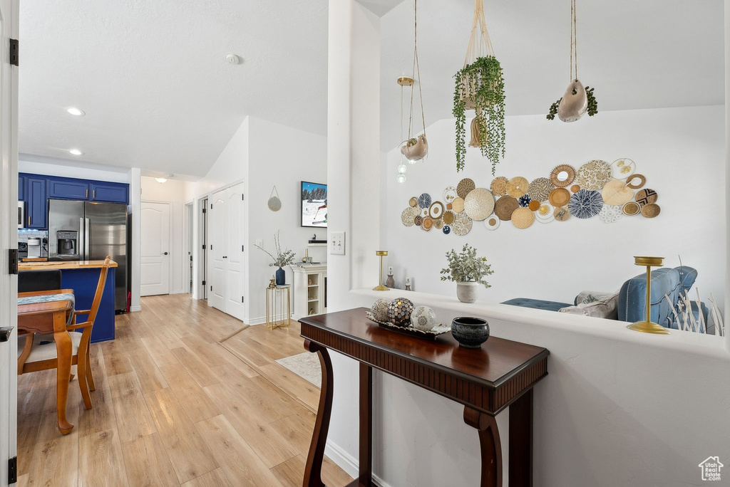 Living area with light wood-style flooring and recessed lighting
