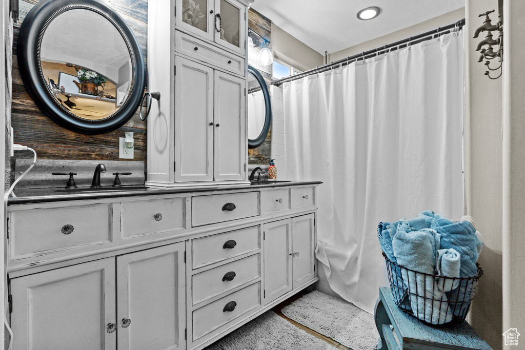 Bathroom featuring curtained shower and vanity