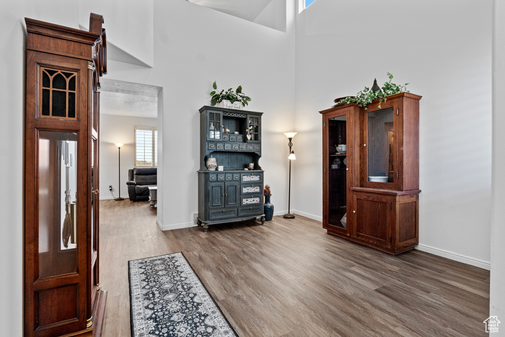 Entrance foyer with dark wood finished floors, baseboards, and a towering ceiling