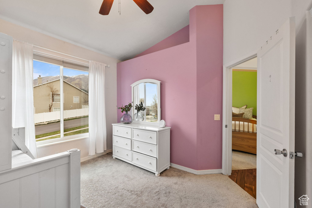Bedroom featuring baseboards, ceiling fan, lofted ceiling, radiator, and light colored carpet
