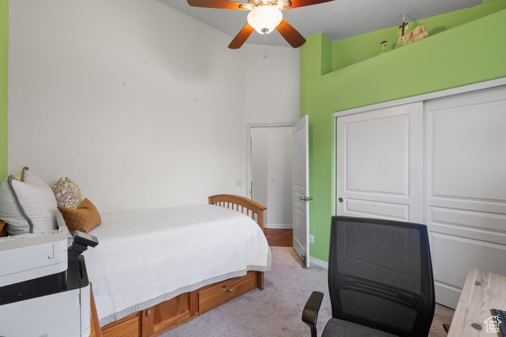 Bedroom with a ceiling fan, baseboards, a closet, and light colored carpet