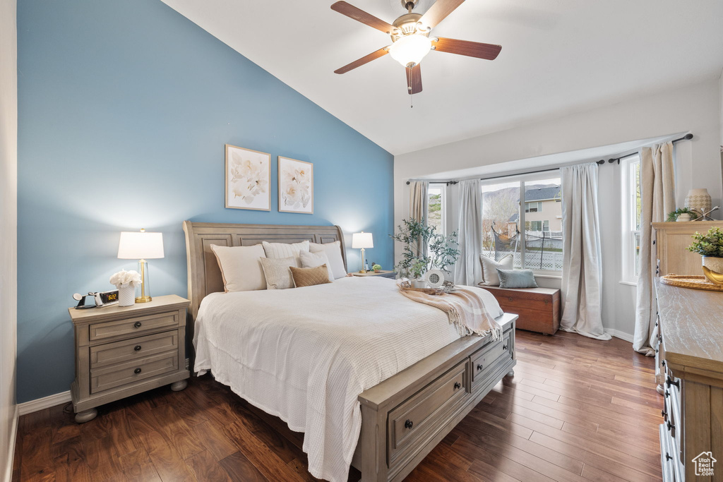 Bedroom featuring baseboards, dark wood-style floors, vaulted ceiling, and a ceiling fan