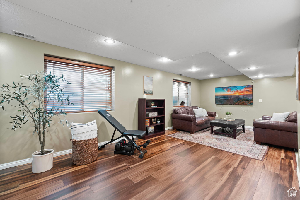 Living area featuring baseboards, visible vents, wood finished floors, and recessed lighting