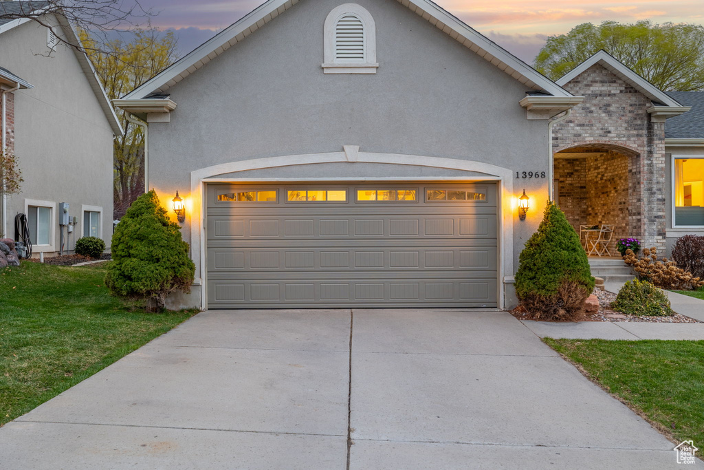 View of front of property featuring stucco siding, a garage, and concrete driveway
