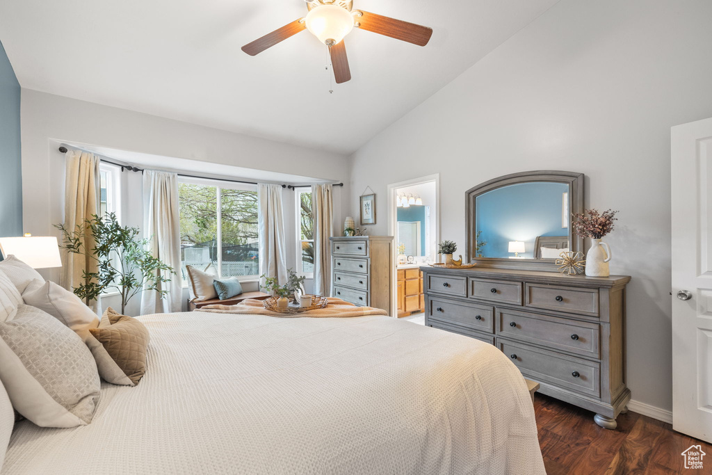 Bedroom featuring ensuite bathroom, baseboards, ceiling fan, dark wood-type flooring, and vaulted ceiling