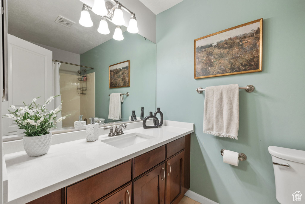 Bathroom with visible vents, toilet, vanity, a shower with curtain, and an inviting chandelier