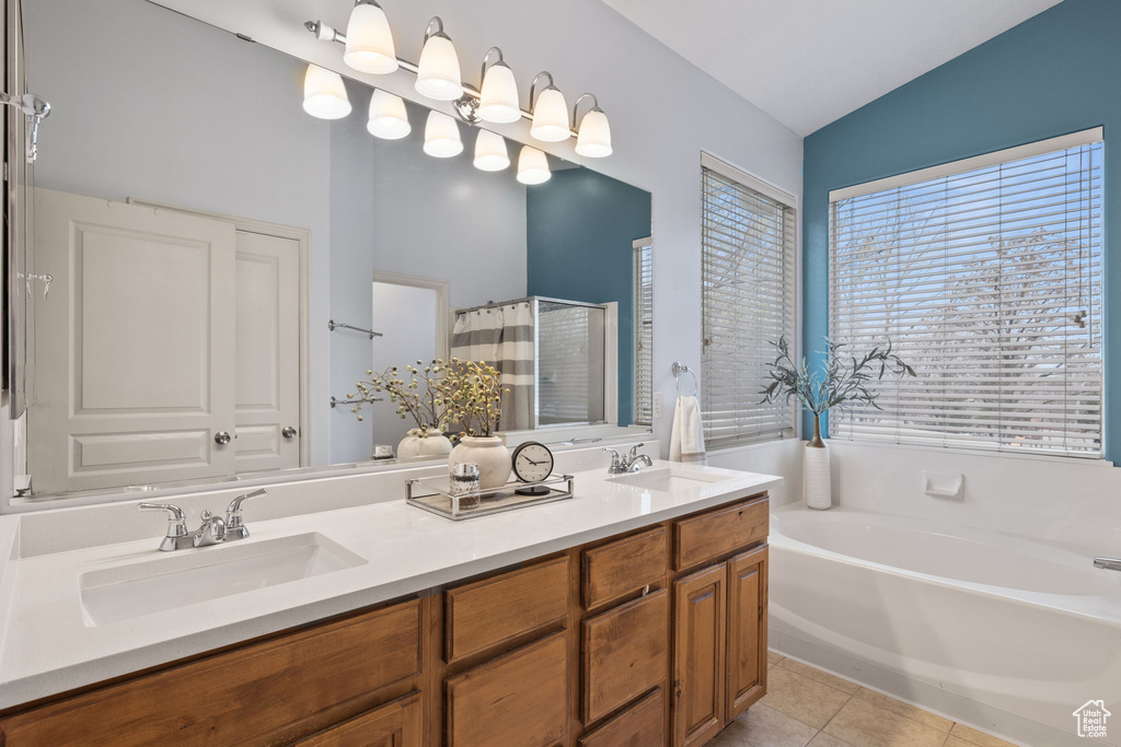 Full bath featuring tile patterned floors, double vanity, a sink, and a garden tub