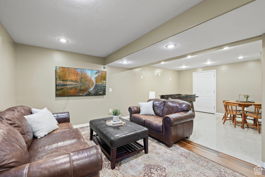 Living room with baseboards, light wood finished floors, and recessed lighting