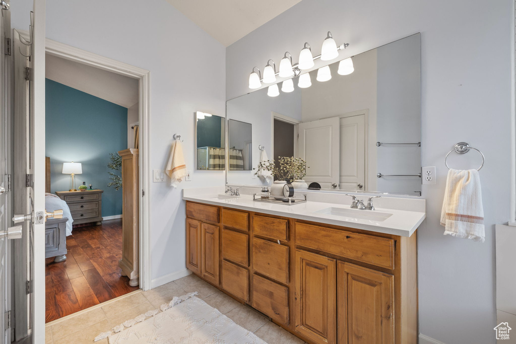 Ensuite bathroom featuring ensuite bathroom, double vanity, a sink, and tile patterned flooring