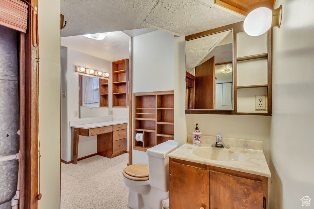 Bathroom featuring toilet, vanity, and baseboards
