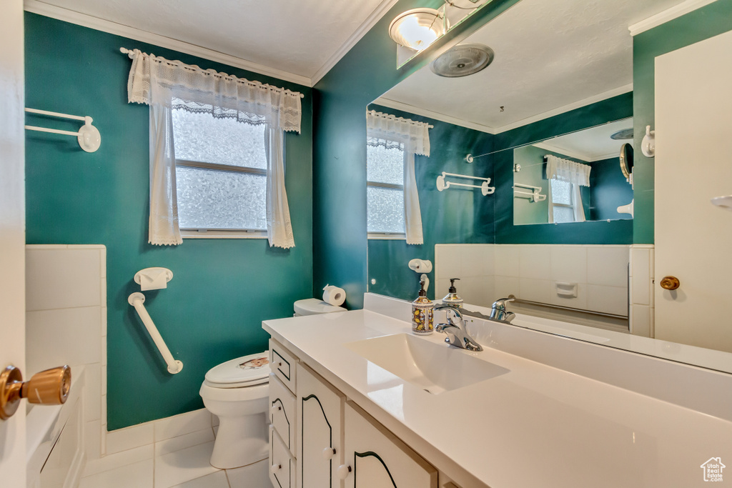 Full bathroom with tile patterned floors, crown molding, toilet, a shower, and vanity