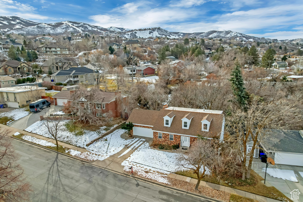 Snowy aerial view featuring a residential view and a mountain view