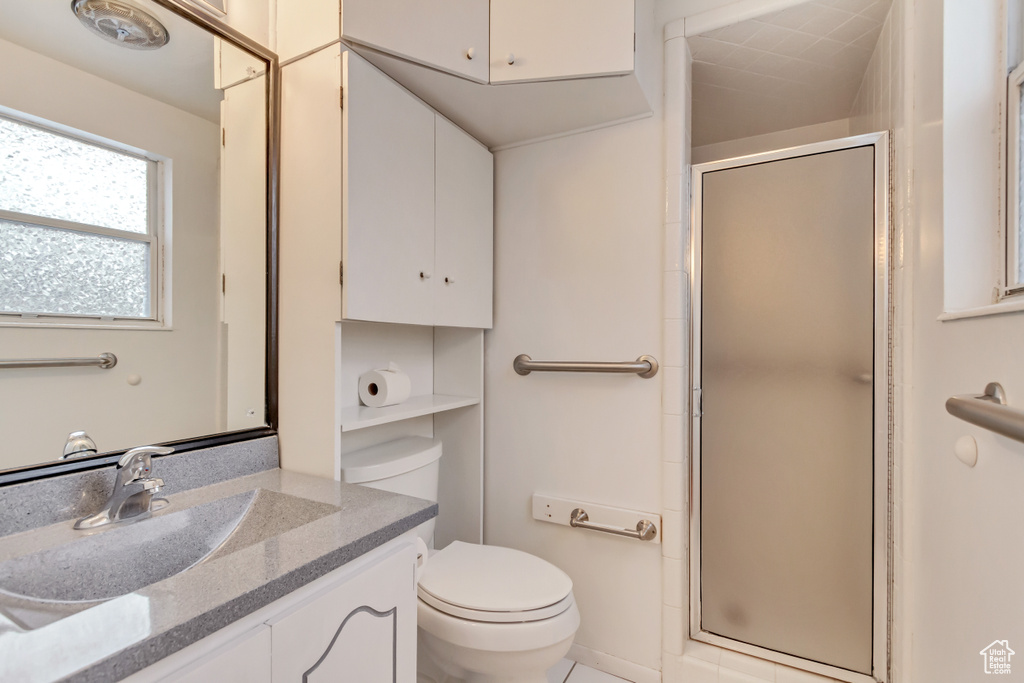 Full bath featuring toilet, vanity, and a shower stall