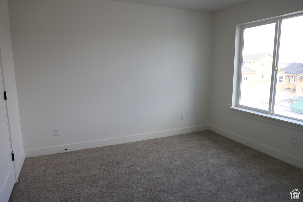 Empty room with baseboards and carpet