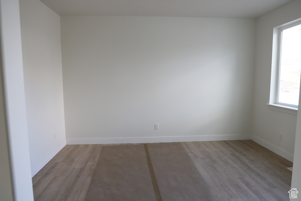 Spare room with baseboards and light wood finished floors