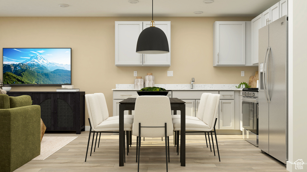 Kitchen with white cabinetry, light wood-style flooring, and stainless steel appliances