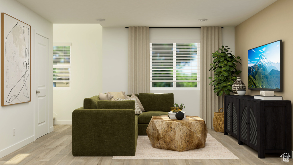 Sitting room featuring plenty of natural light, baseboards, and light wood-style flooring