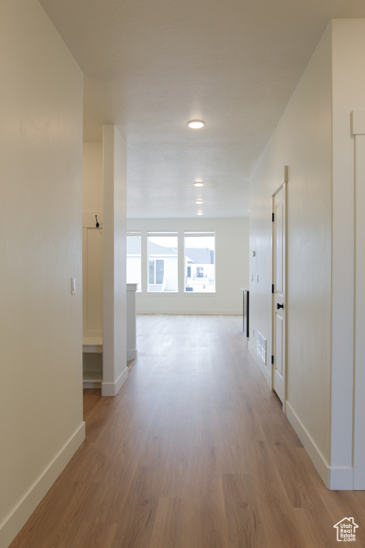 Hallway featuring wood finished floors and baseboards