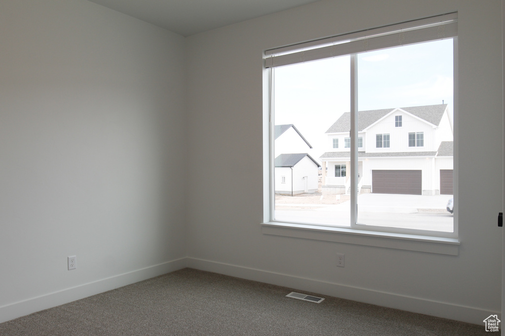 Carpeted spare room with baseboards and visible vents