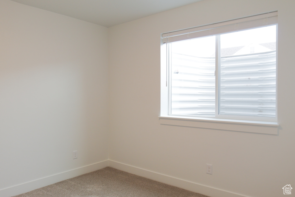 Unfurnished room featuring baseboards and light colored carpet