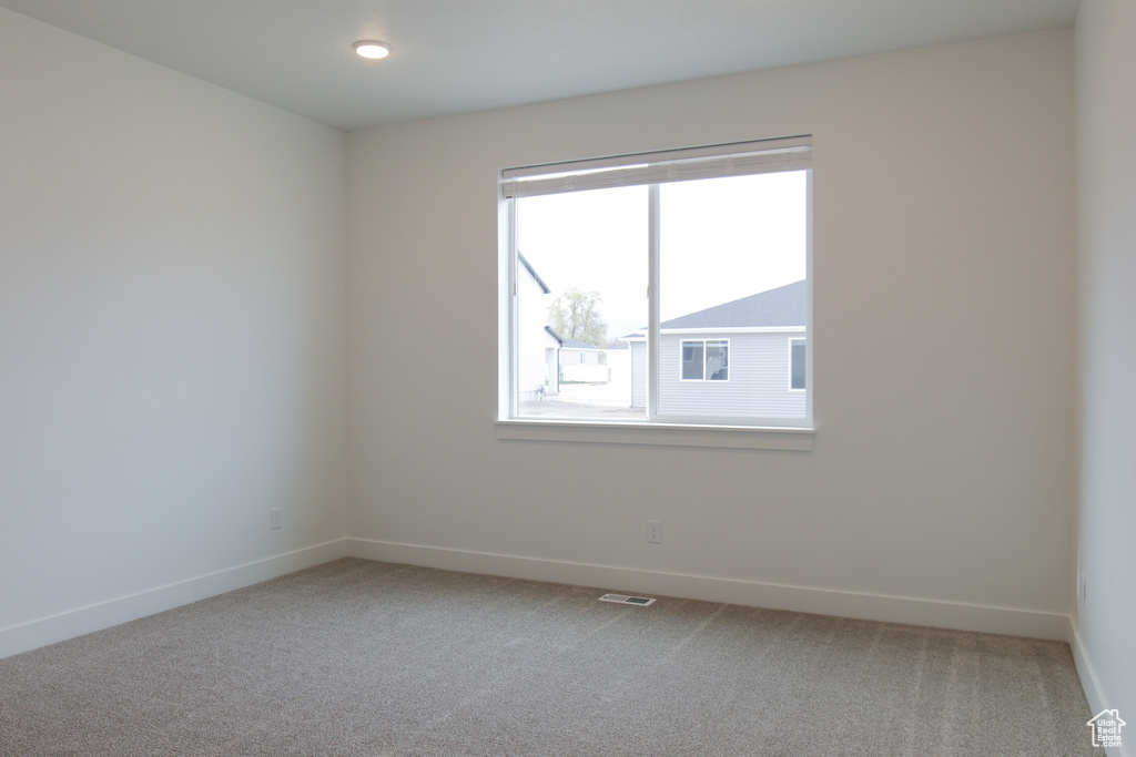 Unfurnished room with light carpet and baseboards